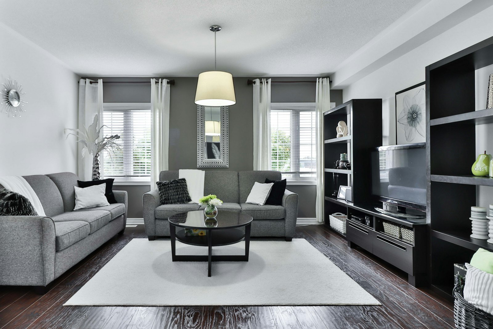 A living room with blinds behind sheer curtains