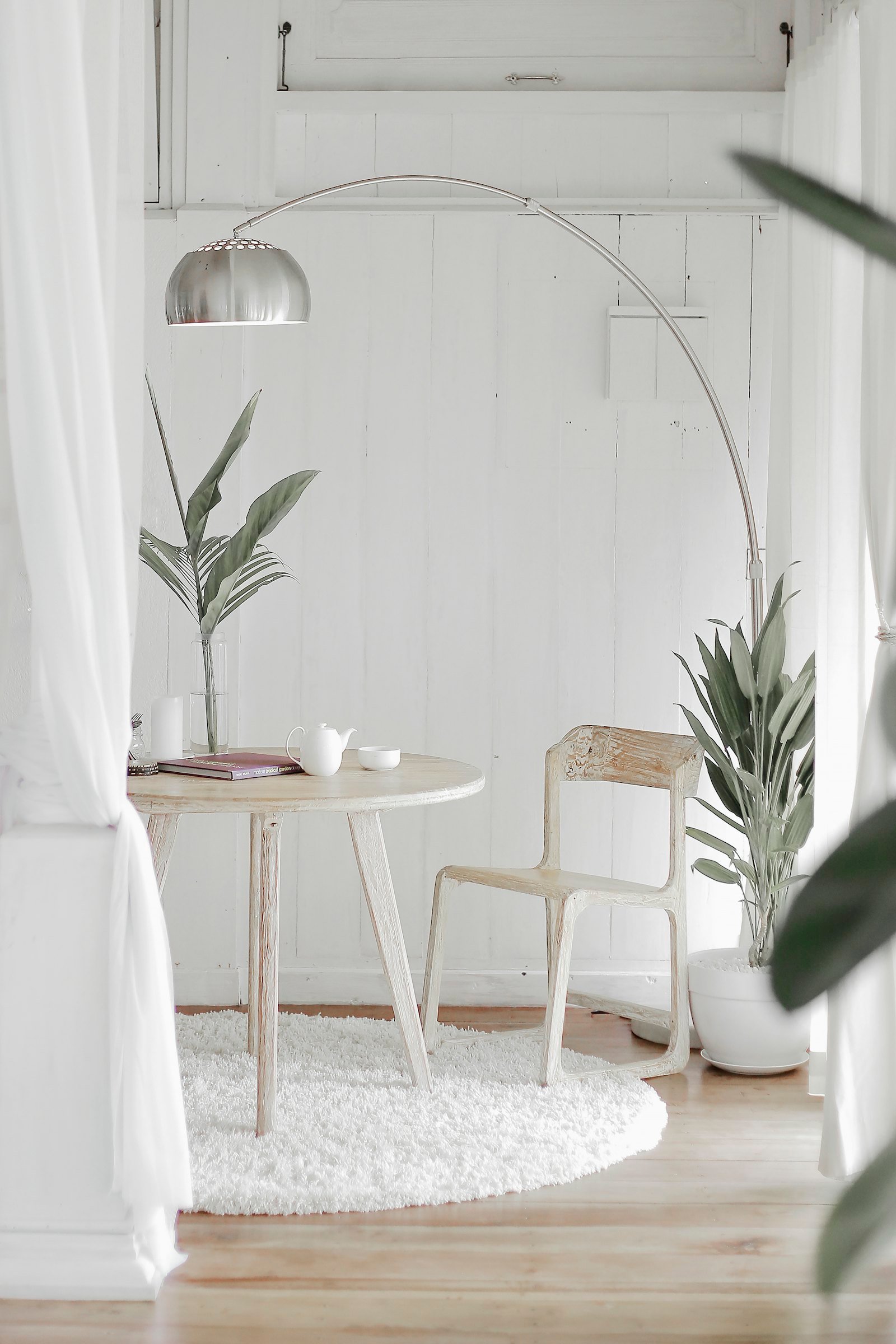Sheer white curtains framing a small round rug