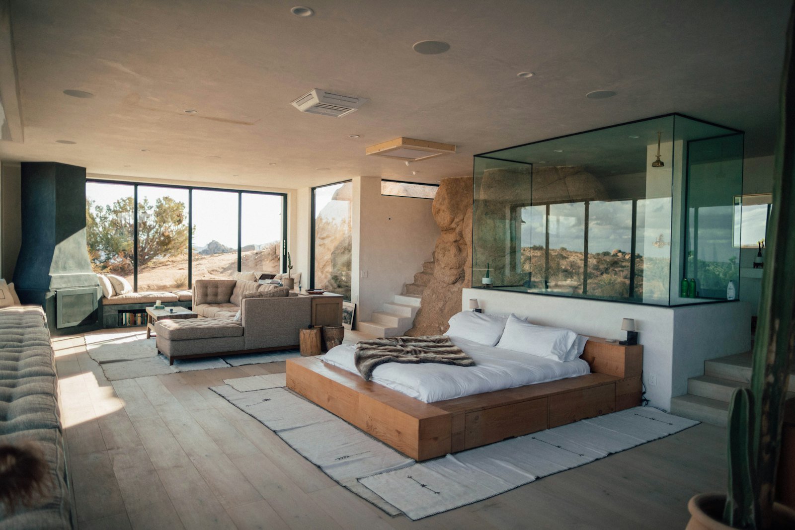 Pale rugs layered beside a low wooden bed
