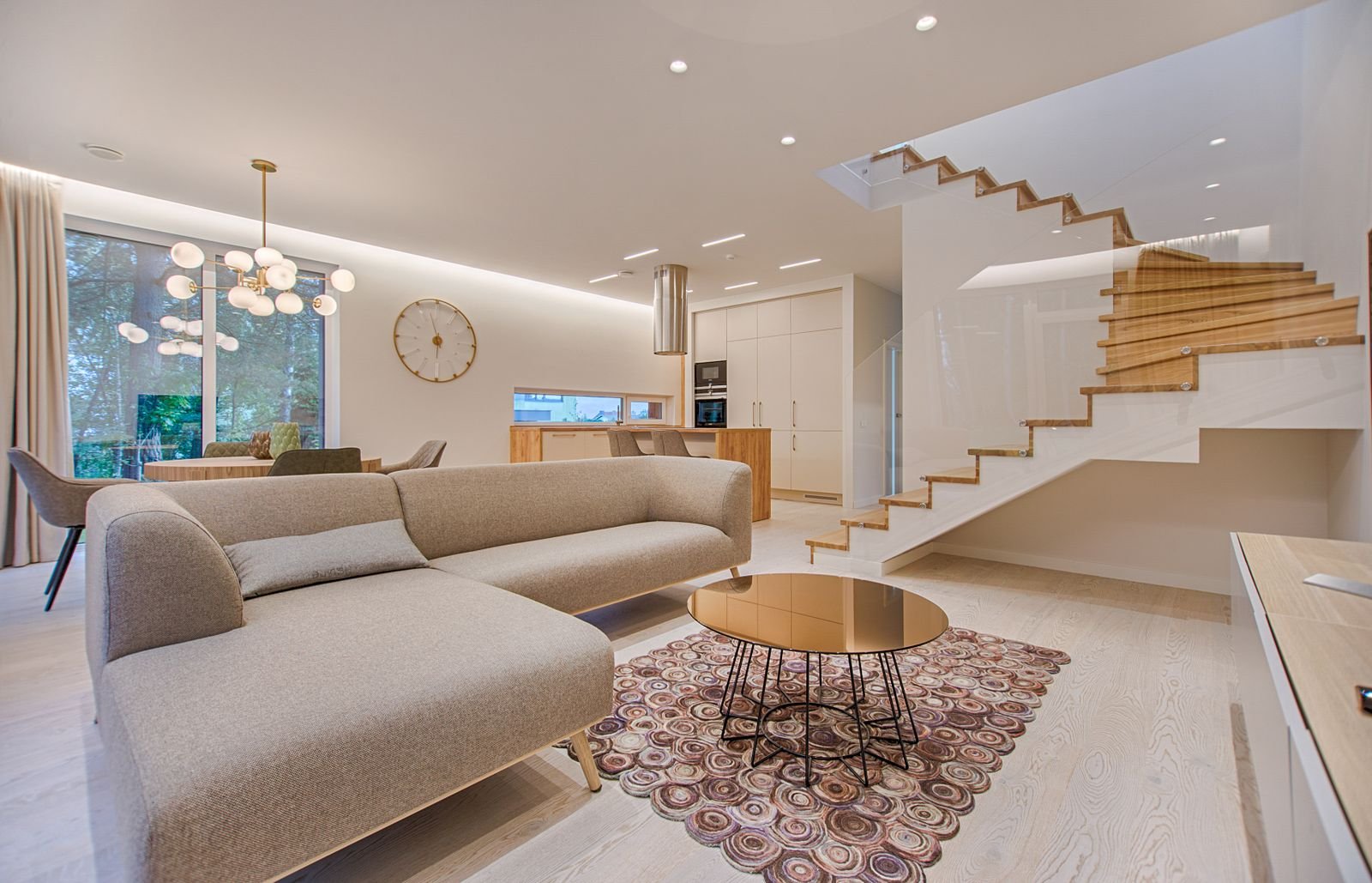A round patterned rug beneath a glass coffee table