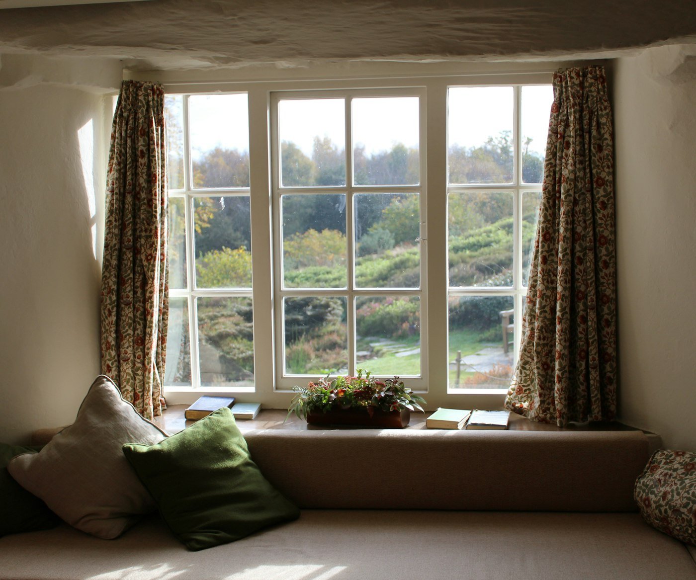 Patterned designer curtains tied back at a window seat