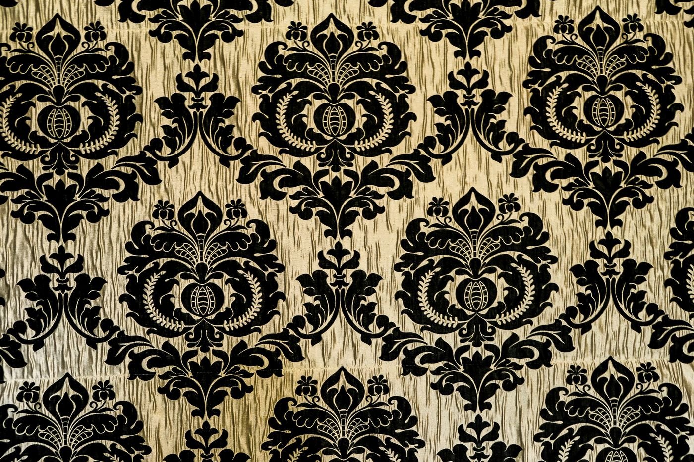 A gold and black damask wallpaper pattern